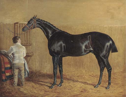 A racehorse in a stable with a groom